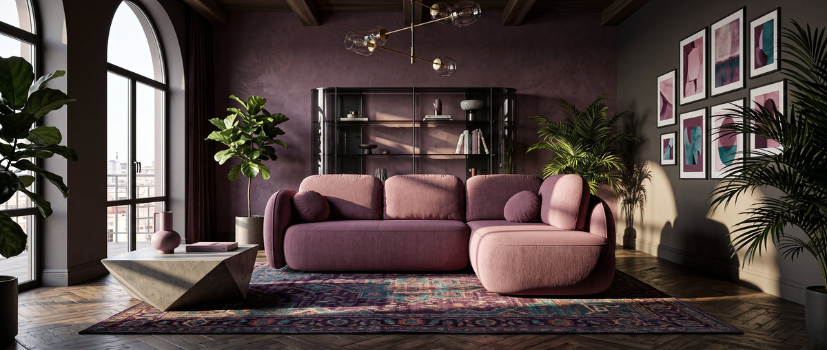 Elegant living room with a pink Olemo corner sofa, a decorative rug, plants and large arched windows