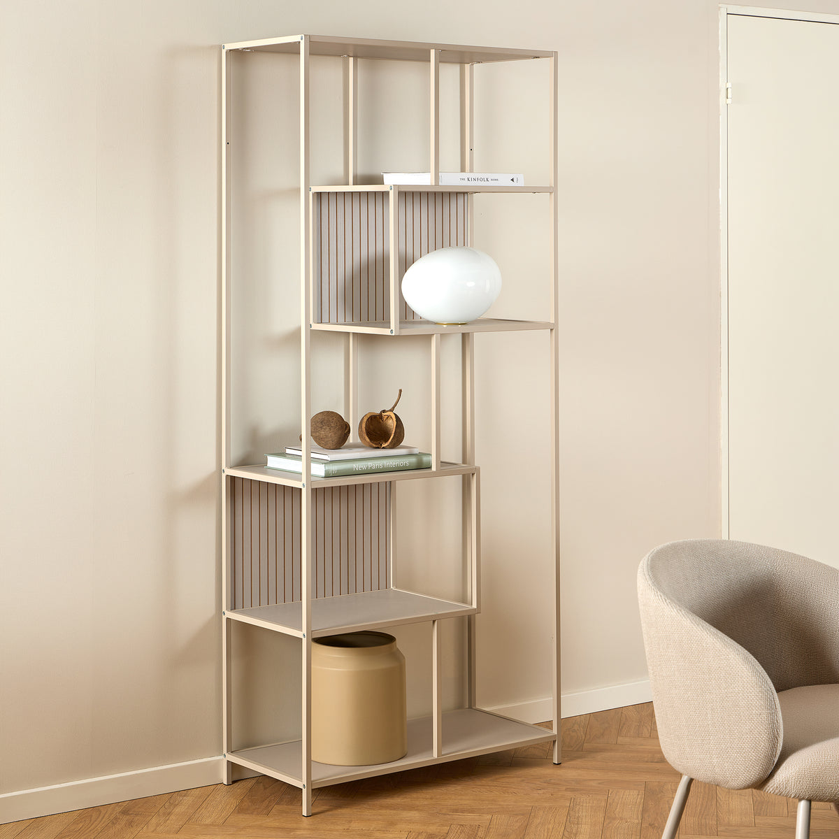 Skeleto-boekenkast 77x185, grijze melamine, in een lichte kamer naast een fauteuil, met een bolvormige lamp – boekenkast voor de woonkamer