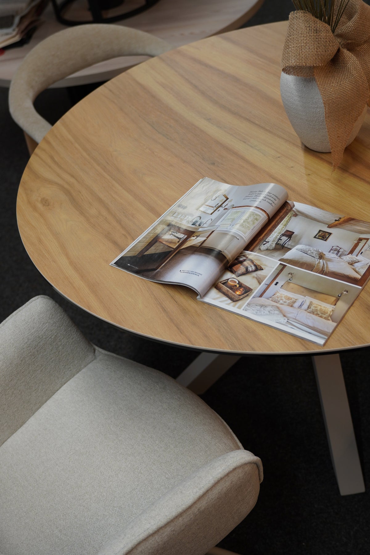 Stela table with a wooden top and an open interior design magazine.