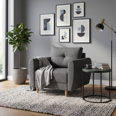 De Harmi-fauteuil van 90 cm in de woonkamer met een galerij met prenten, een plant en een tafeltje met boeken – een fauteuil om in te lezen