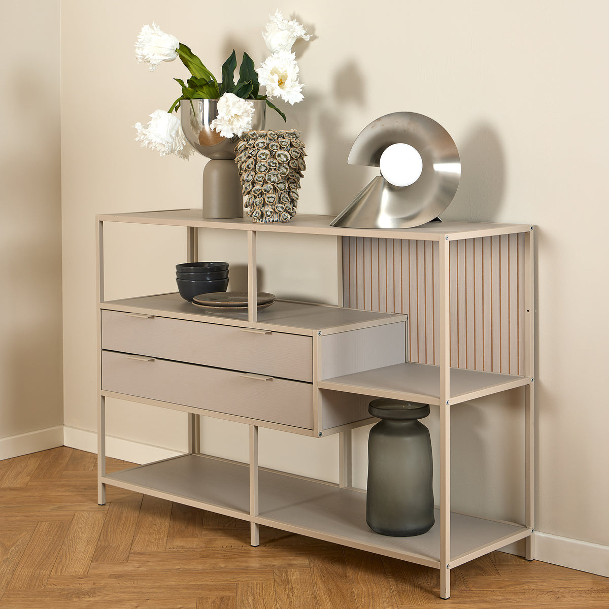 Laag rek Skeleto 114x78 grijze melamine met witte bloemen in een vaas en een zilveren lamp op het blad