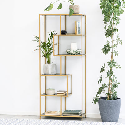 Skeleto-boekenkast 77x185, zwarte melamine (gouden frame) tegen een witte muur, omringd door planten in potten – een glamoureuze boekenkast