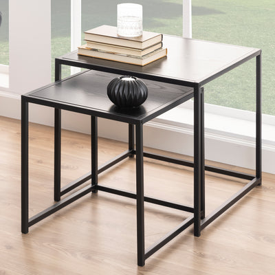 Skeleto-salontafeltjes 50x45, zwart melamine, bij een groot raam, met boeken en een vaas – een set salontafeltjes voor de woonkamer