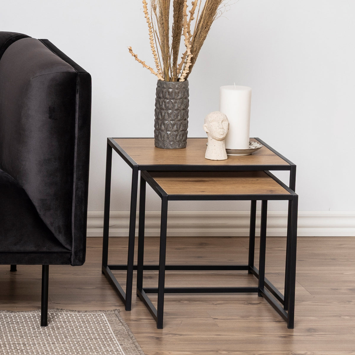 Skeleto-salontafels 50x45 Wild Eiken naast een donkere veloursbank, met een vaas en een kaars – salontafels voor de woonkamer