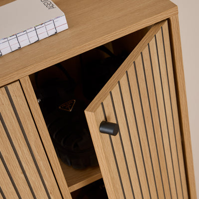 Schoenkast Bambouz 99x141 – detail van de halfopen deur met zwarte knop en schoenen op de plank